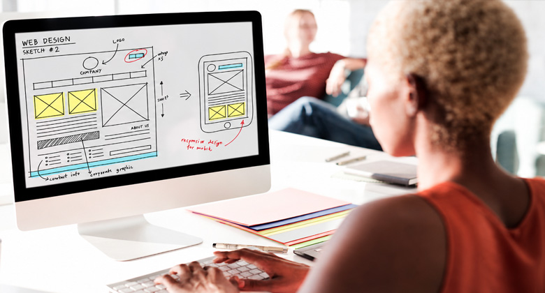 Designer reviewing a luxury website layout on a desktop screen